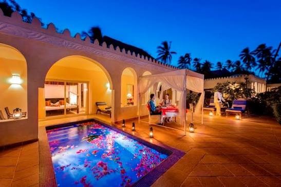 Resort villa at night with a private pool and outdoor dining area