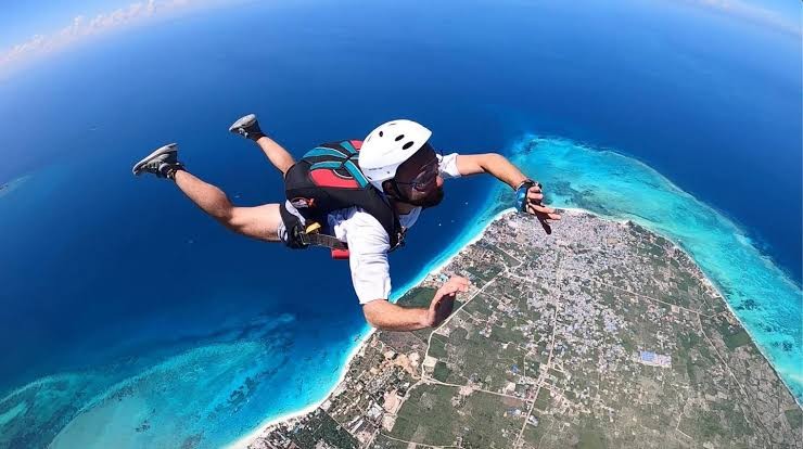 A skydiver in freefall above the coast of Zanzibar