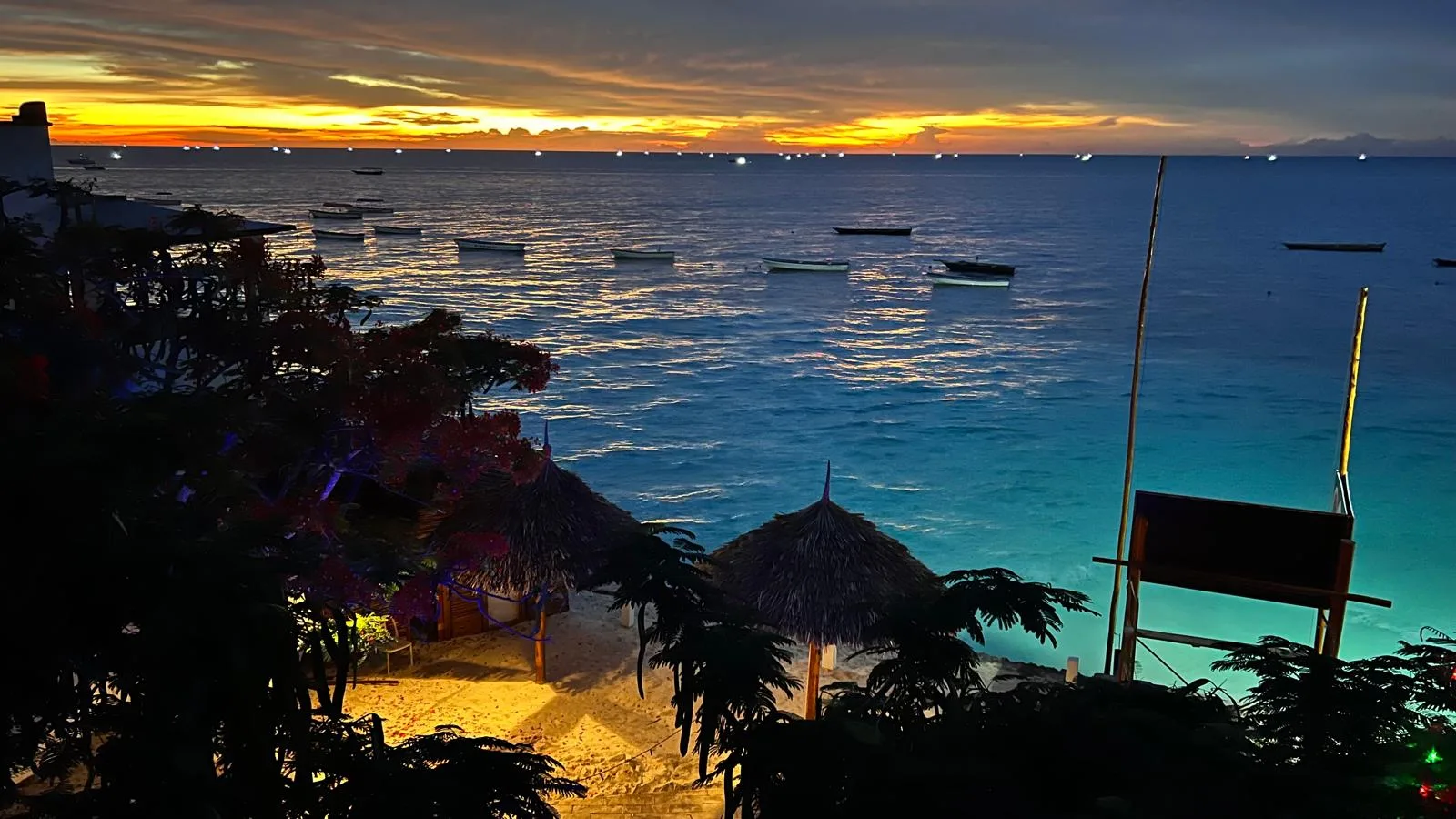 Nungwi beach sunset with thatched umbrellas and boats