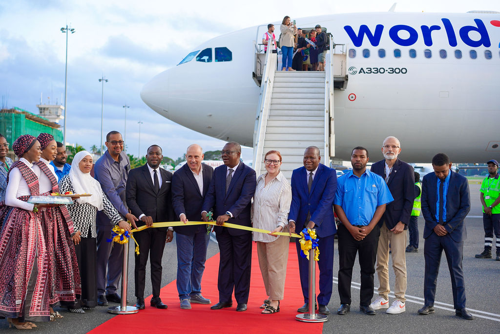 Safina Tours ribbon cutting ceremony in front of an aircraft
