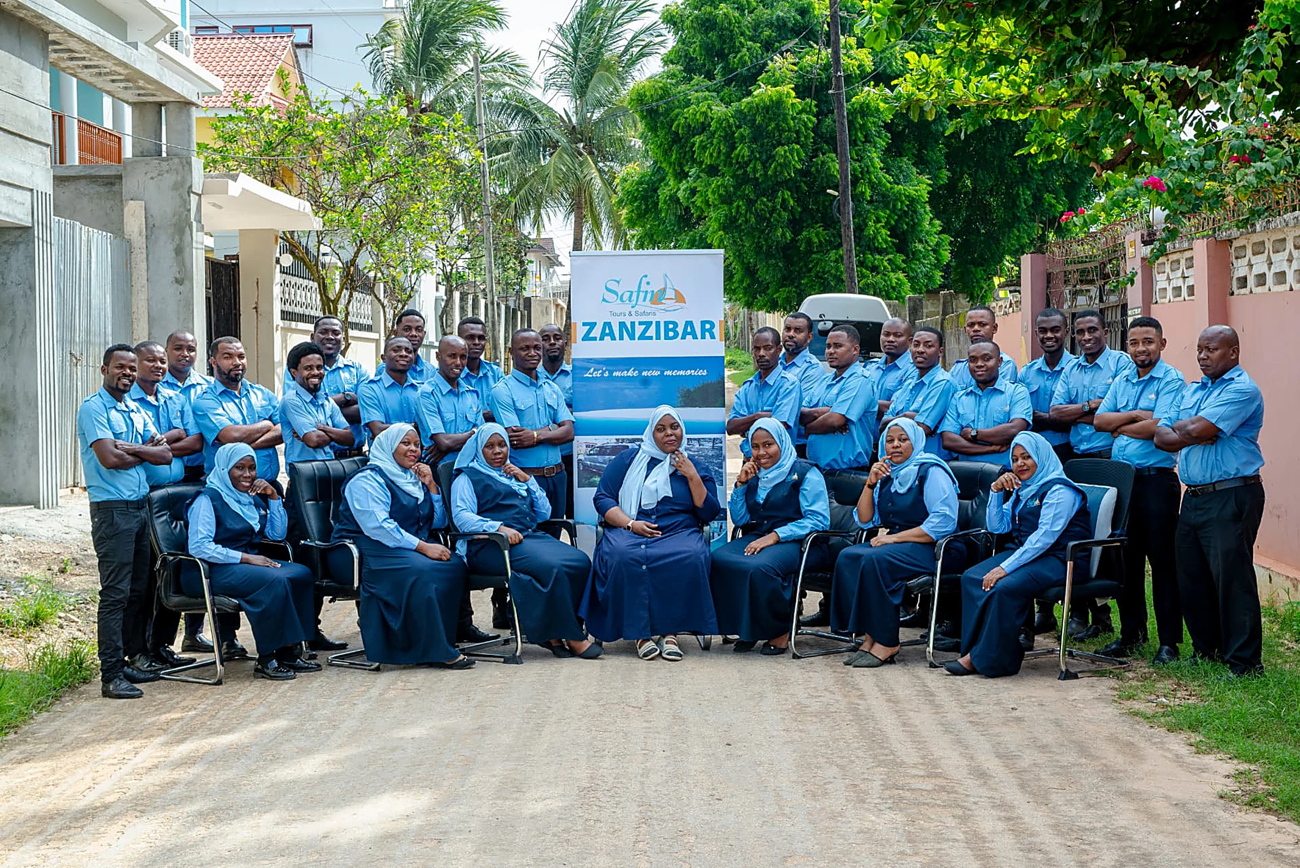 The full Safina Tours & Safaris staff team photographed around the company banner